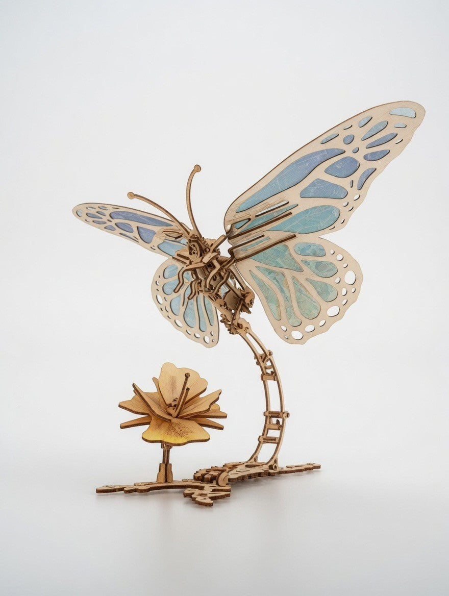 ImagineHaul UGEARS Butterfly mechanical wooden model kit with blue wings and a wooden flower. 168 birch plywood pieces, no glue needed.