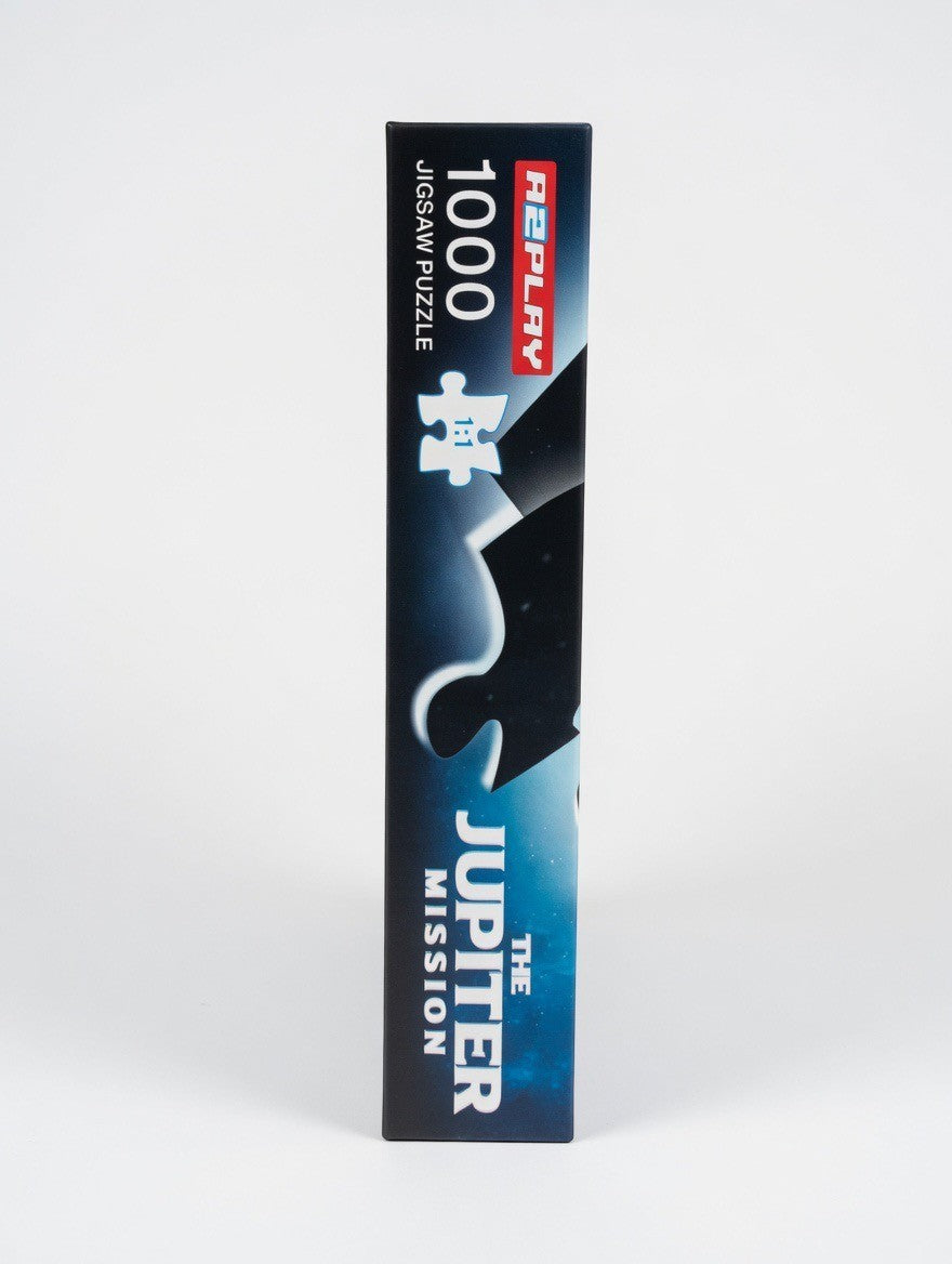 ImagineHaul A2PLAY The Jupiter Mission 1000-piece jigsaw puzzle box side view, featuring space artwork and text.