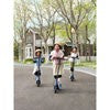 Three children riding blue Ninebot by Segway C2 Lite electric scooters down a suburban street, enjoying a sunny day.